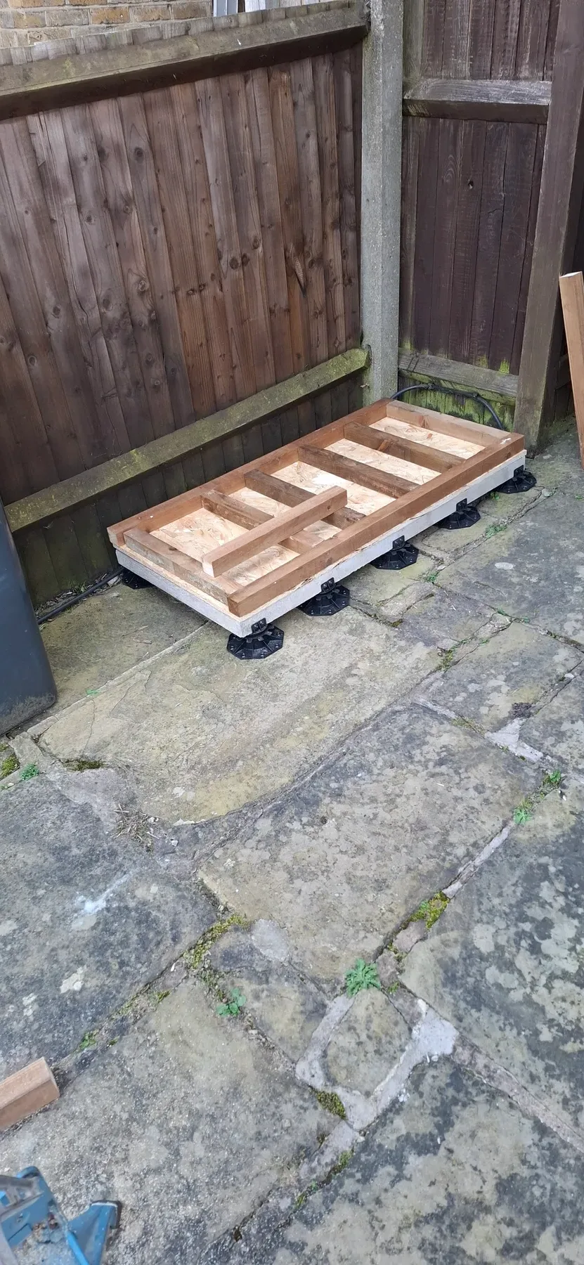 Close-up of the base frame, joists and OSB board, sitting on the levelling pedestals