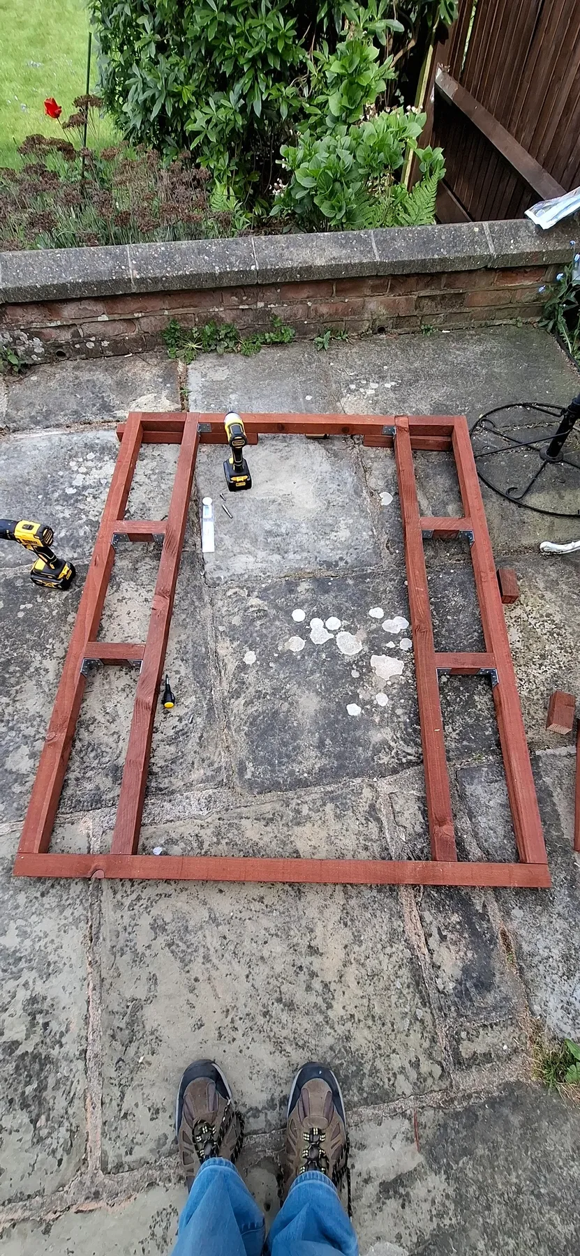 The first wall frame, assembled flat on the patio with corner brackets fitted