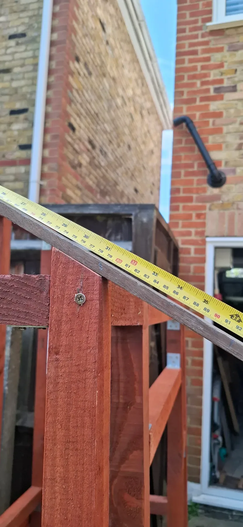 Measuring along the sloped roof beam where it meets the house wall