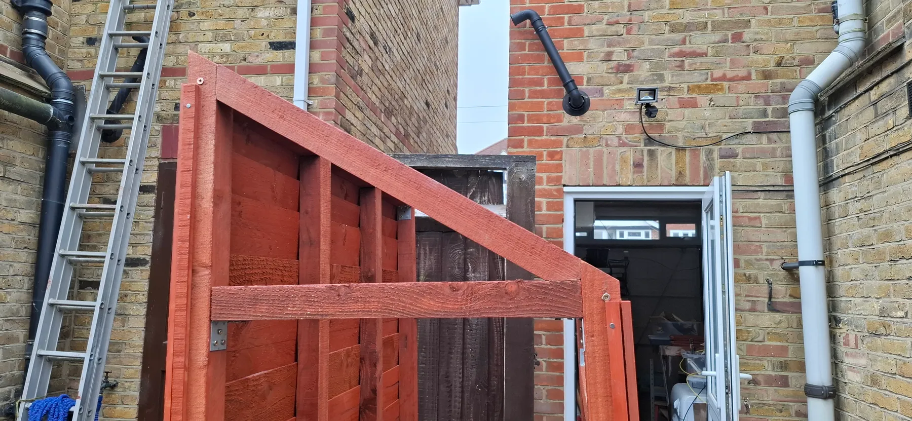 The roof beam bolted to the brickwork of the house