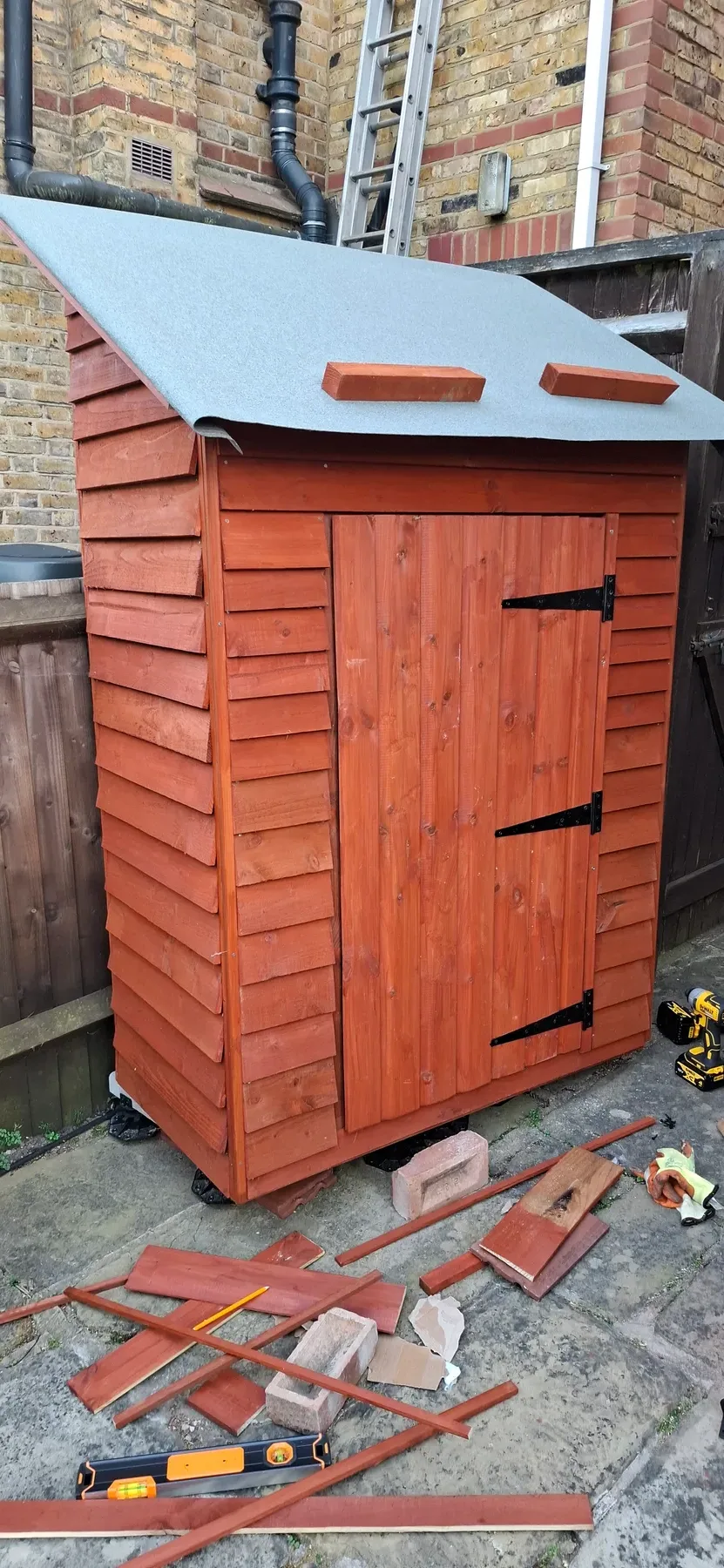 The finished shed, doors hung with black hinges, cladding complete